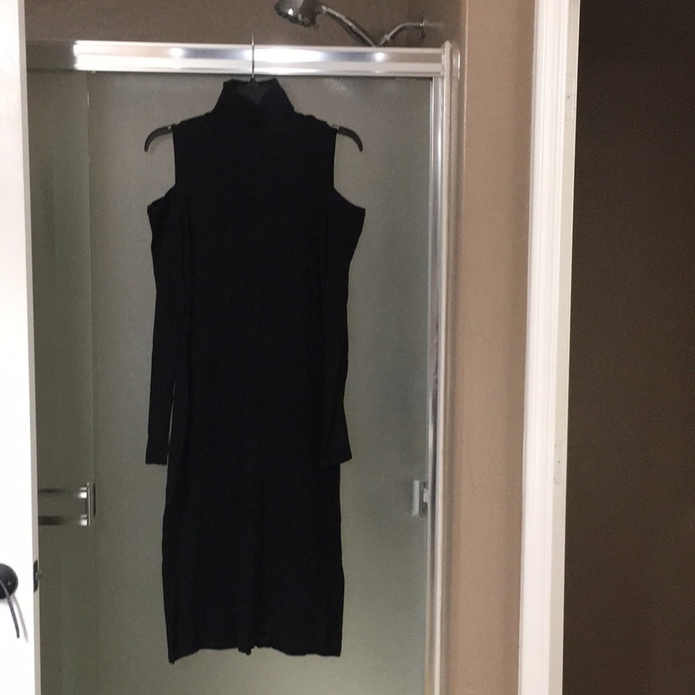 Open shoulder knit black dress .